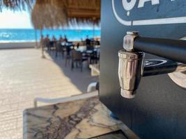 Metal shiny chrome faucets of a cooler with water and drinks, close-up view. Faucet for pouring drinks photo