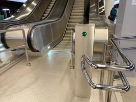 Large comfortable fast metal modern escalators with automatic steps for going up and down the subway or shopping and entertainment center photo