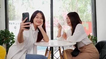 Aziatisch vrouw en meisje vriend gebruik makend van smartphone selfie samen in koffie winkel. mooi vrouw hebben genieten levensstijl video