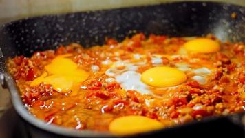 fritte uova nel georgiano cucina, chirbuli. uova con pomodori cottura a vapore nel il padella video