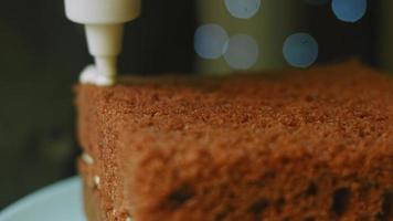 Le pongo la nata a la tarta con ayuda de una bolsita de confitería. pastel de navidad con galletas de jengibre en forma de santa claus video