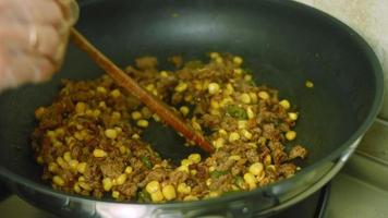 mélanger l'oignon haché, le poivron haché et la viande de chorizo. faire frire dans une poêle. prise de vue macro video