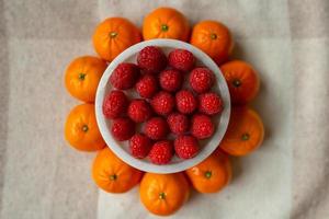 Raspberries and tangerines close-up. Fruits are good for health. Proper nutrition, raw food. photo