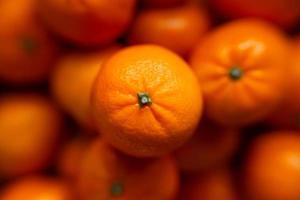 Basket with tangerine or orange fruit on a gray plaid background. photo