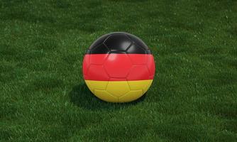 Soccer ball with Germany flag colors at a stadium on green grasses background. photo