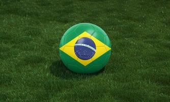 Soccer ball with Brazil flag colors at a stadium on green grasses background. photo