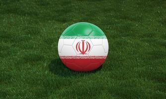 Soccer ball with Iran flag colors at a stadium on green grasses background. photo