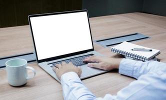 Businessman put your hand on keyboard and white screen background mock up on display laptop with clipping path photo