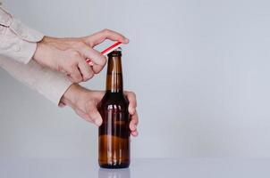 mano abriendo una botella de cerveza para el concepto del día internacional de la cerveza. foto