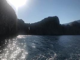 vista de las montañas y el agua en el mar y el océano en la naturaleza en un día muy soleado. paisaje foto