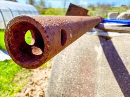 a rusty stick lies in the country. metal reinforcement lies on the ground and is covered with corrosion. old, rusty, dirty piece of an unnecessary fence photo