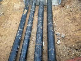 construction of a new neighborhood in the city. black long pipes are laid underground for communications. underground communications with water photo