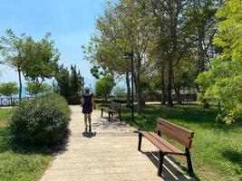 Outdoor Workouts Happy Blonde Woman in Sportswear Walking in the Park While Listening to Music on the Smartphone photo