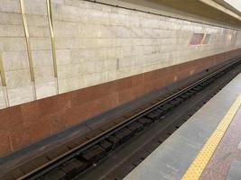 View of the tunnel on the platform for waiting trains at the metro station with granite walls