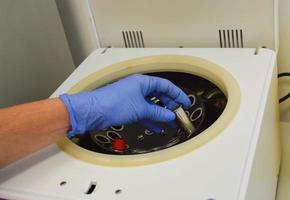 Lab man puts in centrifuge tube with blood for testing coronavirus.Tests for detection virus Sars-cov-2 causing covid-19 and specific antibodies IgM and IgG meaning that exists immunity.Vaccine photo