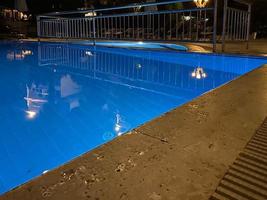 vista panorámica de la lujosa piscina con pared de ladrillo y tumbona foto