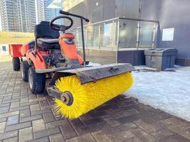 construction of houses. cleaning with the help of a special car with a huge brush for cleaning asphalt. a driver control car stands on the pavement without work waiting for a person photo