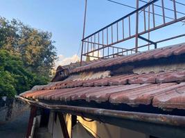 Red ceramic tiles on the roof of the house vintage natural ancient old beautiful, close view. Natural classical building materials for the roof photo