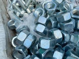 Background, texture of many metal small iron nuts and stainless steel fasteners, fittings and mitiz photo