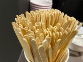 Natural wooden disposable sticks for mixing sugar in tea or coffee in a cafe photo