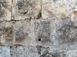 un fragmento de un muro de piedra hecho de piedra toscamente labrada foto