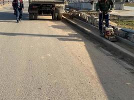 Road works for laying asphalt while repairing the road by workers using construction equipment photo