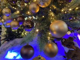 grandes bolas de navidad en el árbol. ramas verdes de abeto con juguetes. primer plano de guirnaldas brillantes. fondo de navidad. Año Nuevo foto