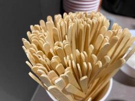 Natural wooden disposable sticks for mixing sugar in tea or coffee in a cafe photo