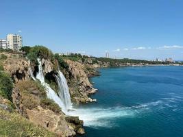 Aerial panoramic image of Lower Duden waterfall in Antalya, Turkey. Water falls drop off rocky cliff directly into Mediterranean sea in sunny summer day photo