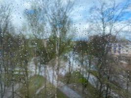 Beautiful surface texture of wet transparent glass in a window with clean cold drops after rain. The background