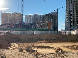 Tall concrete houses are being built in the city center. multi-storey buildings, concrete boxes against the backdrop of large photo