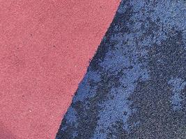 Baldosa de seguridad antitraumática con superficie de goma azul y rosa para juegos deportivos de entrenamiento en parques o patios públicos. el fondo. textura foto