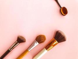 Makeup brushes and powder, forming a circle on a light background. Horizontal template for make-up artist business card or flyer design photo