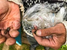 el hombre sostiene un paquete con varias herramientas de reparación. un hombre atraviesa clavos, tuercas, pernos. en su mano hay varias herramientas de reparación. manos de un amo, esposo por una hora foto