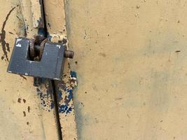 Yellow old scratched padlock metal sheet, iron rusty surface with peeling paint. The background. Texture photo