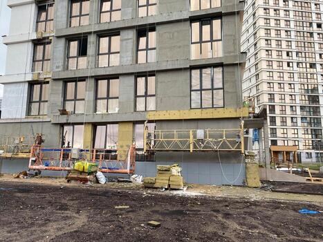 External finishing with mineral wool insulation in the cradle of the assembly of a new facade of a high building of a building made using monolithic-frame construction technology photo
