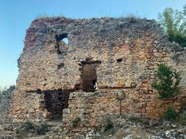 The ruins of an ancient old broken ruined medieval fortress made of cobblestones and bricks in a tourist warm tropical eastern country southern resort photo