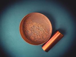 Beautiful fashionable beauty cosmetic glamorous jar with powder for applying makeup on the face on a blue gentle background photo