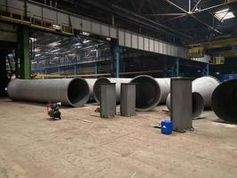 Production of large diameter steel pipes at a metallurgical plant. Soft focus. Close-up photo