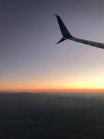 Golden sunset sky with fluffy ornamental cumulus clouds, panoramic view from an airplane, wing close-up. Dreamlike cloudscape. Travel, tourism, vacations, weekend, freedom, peace, hope concepts photo