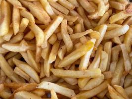 Delicious yellow golden french fries, rustic potato fried in oil, fast food. The background. Texture photo