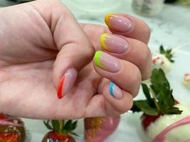 diseño de arcoíris en uñas largas y ovaladas. arte de uñas. manicura francesa multicolor foto