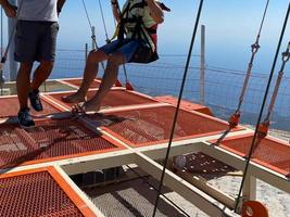 el instructor prepara a una persona para un salto extremo sobre una cuerda o banda elástica desde una gran altura. salto de cuerda deporte extremo foto