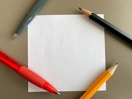 Small square pieces of paper for notes and notes on the office desk and ballpoint pens with pencils. Business work photo