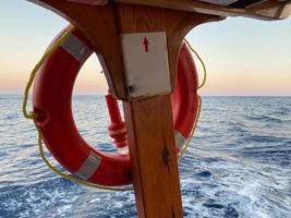 boya salvavidas. aro salvavidas rojo en una barandilla de crucero foto