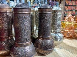 Beautiful metal Turkish manual coffee grinder shiny carved oriental decorative with in a tourist souvenir shop photo