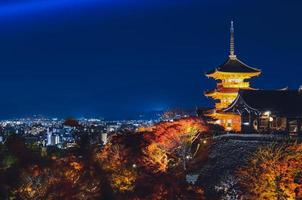 templo kiyomizu-dera en la temporada de otoño en la escena nocturna con el fondo de la ciudad de kyoto en japón. foto