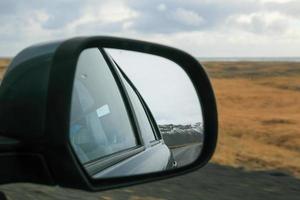 Rear view mirror with mountain road by winter photo