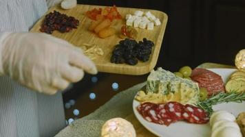 Flat charcuterie with salami, different kinds of cheese. It has dried fruits, various nuts and honey. Holiday arrangement with burning candles video