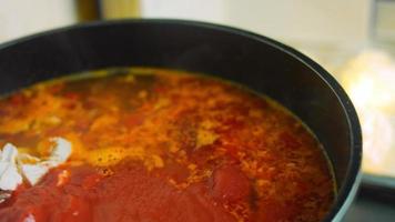 Mischen Sie die Zutaten für die mexikanische Suppe mit einem Holzlöffel. Makroaufnahmen video